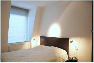 um quarto com uma cama branca e uma janela em Residence Ruimzicht - Baddomburg em Domburg