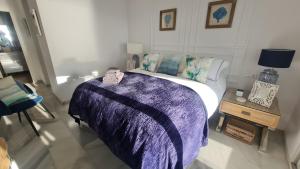 a bedroom with a bed with a purple blanket at 240 Front line beach La Cala in La Cala de Mijas +6 photos