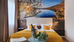 ein Schlafzimmer mit einem gelben Bett und einem Gemälde an der Wand in der Unterkunft Hotel "Zum Moseltal" in Mehring