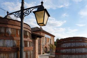 una luz de la calle delante de dos barriles en Hotel Le Botti, en Guarene