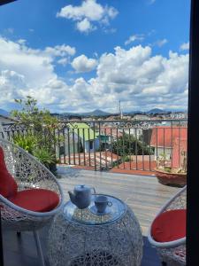 een tafel en stoelen op een balkon met uitzicht op een stad bij Ánh Dương House in Da Lat
