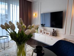 a vase of flowers on a table in a living room at Nr 12 EUROPA22 Exclusive z Garażem podziemnym in Tomaszów Mazowiecki +15 photos