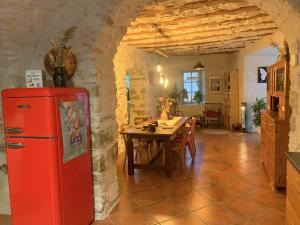 een keuken met een rode koelkast en een tafel bij La Magnanerie de Dions in Dions