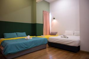 two beds in a room with green and yellow at Desa Hill Eco Villa 12 by Vale Pine in Kuala Lumpur