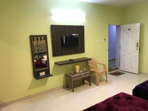 een kamer met een spiegel, een tafel en een stoel bij HAPPYSTAY rooms and cottages in Ooty