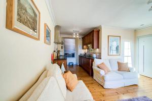 ein Wohnzimmer mit einem weißen Sofa und einer Küche in der Unterkunft GuestReady - Historic Edinburgh Old Town Apartment in Edinburgh