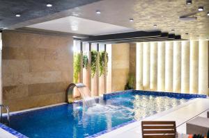 a swimming pool with a waterfall in a hotel room at Amsterdam Hotel in Belgrade