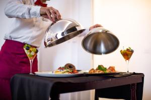 a person preparing a plate of food on a table at Amsterdam Hotel in Belgrade
