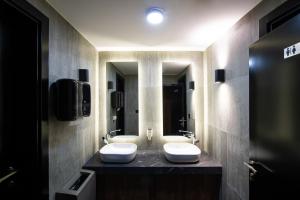 a bathroom with two white sinks on a counter at Amsterdam Hotel in Belgrade