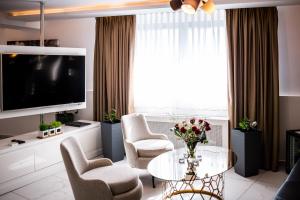 a living room with a table and chairs and a tv at Amsterdam Hotel in Belgrade