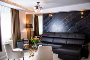 a living room with a leather couch and a table at Amsterdam Hotel in Belgrade
