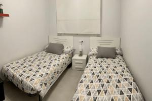 two beds sitting next to each other in a room at Nova Beach Super cool seaview apartment in Santa Pola +17 photos