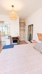 ein Schlafzimmer mit einem großen Bett mit einem Tisch und einem Zimmer in der Unterkunft L'Elégant - Idéal Couple - Parking Gratuit in Pau