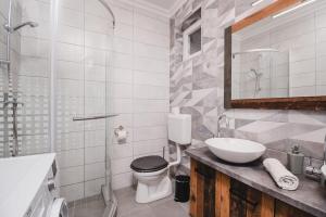 a bathroom with a toilet and a sink at Reborn Lux Apartments in Hajdúszoboszló +18 photos