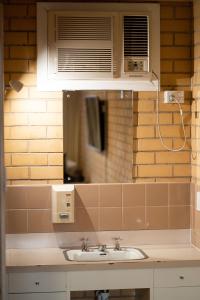 ein Badezimmer mit einem Waschbecken und einer Mikrowelle in der Unterkunft Bentley's Hotel in Clare