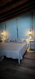 a bedroom with a white bed with a blue wall at masia riu dels arbres in Benasal