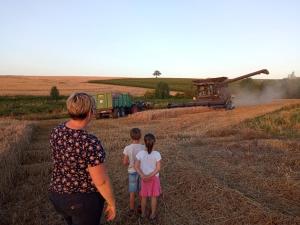 a woman and two children looking at a plane in a field at AU NID DOUILLET DE LA FERME CHAUVET in Chantenay-Villedieu