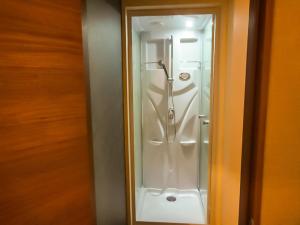 een douche in een badkamer met een glazen deur bij Relak Guest House 登別 Station in Noboribetsu