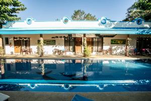 une maison avec une piscine en face de celle-ci dans l'établissement Floral Villarosa, à Puerto Princesa