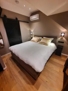 um quarto com uma cama grande com lençóis brancos e almofadas em B&B de Maaskei em Guelle