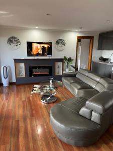 sala de estar con sofá y chimenea en Palm beach Sydney, Modern home with water view, en Palm Beach