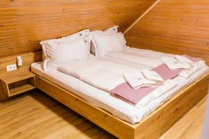 Una cama en una habitación de madera con toallas. en Chalet Liza & Rozi, en Zgornja Ložnica