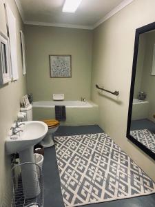ein Badezimmer mit einem Waschbecken, einer Badewanne und einem WC in der Unterkunft Wild Fig Guesthouse in White River