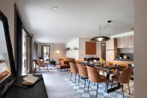 a kitchen and living room with a table and chairs at Résidence Ynycio in Tignes