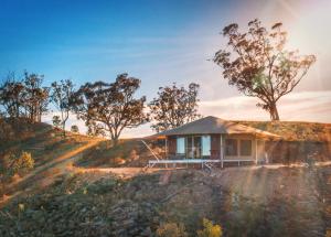 a house on top of a hill with trees at Sierra Escape Luxury Glamping in Piambong