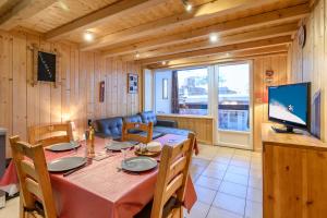 a dining room with a table and a television at Immeuble le Champsaur in Orcières