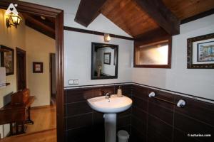 La salle de bains est pourvue d'un lavabo et d'un miroir. dans l'établissement Casa Rural La Cuesta, à Villarmil