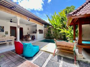 a villa with a swimming pool and a house at Timaya Villa in Legian