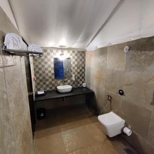 a bathroom with a toilet and a sink and a mirror at Exotic Stay - a unique experience in Pune