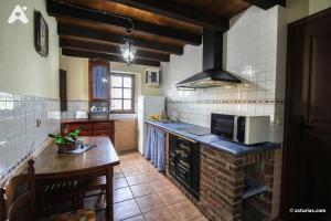 a kitchen with a counter and a stove top oven at Casa Rural La Cuesta in Villarmil +11 photos