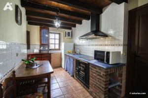 a kitchen with a counter and a stove top oven at Casa Rural La Cuesta in Villarmil