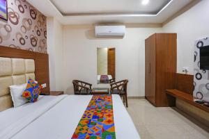 Habitación de hotel con cama y TV en FabHotel Frolic, en Haridwar