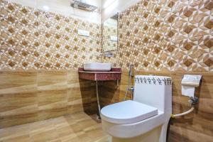 bagno con servizi igienici, lavandino e specchio di FabHotel Frolic a Haridwār