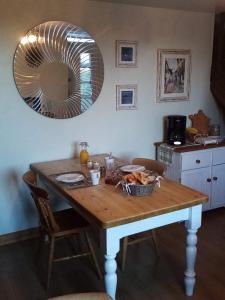 a dining room table with a mirror on the wall at 38 Friaudour in Saint-Pardoux