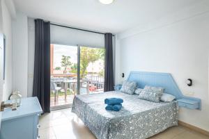 sypialnia z niebieskim misiem siedzącym na łóżku w obiekcie Apartamentos El Velero w mieście Torremolinos