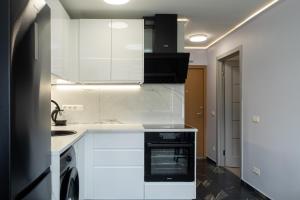 uma cozinha com armários brancos e uma máquina de lavar louça em DAILY Apartment em Anykščiai