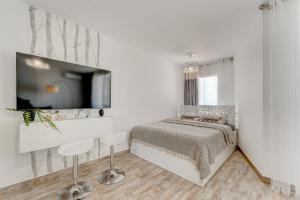 um quarto branco com uma cama e uma televisão de ecrã plano em Park Santiago 2 Luxury Studio 8 em Arona