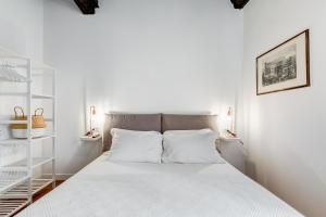 a white bedroom with a large bed with white pillows at Boschetto 118 in Rome