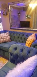 un soggiorno con divano blu e specchio di Ko-Porch luxury guest house a Polokwane