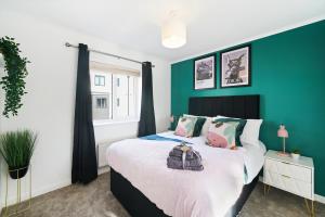 a bedroom with a green accent wall and a bed at Ideal 3 bed House in Wolverhampton - Parking in Wolverhampton