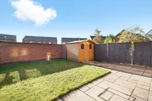 a backyard with a fence and a yard with grass at Ideal 3 bed House in Wolverhampton - Parking in Wolverhampton