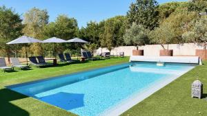 einen Pool im Garten mit Stühlen und Sonnenschirmen in der Unterkunft L'atelier Insolite - Piscine chauffée in Montauban