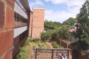 - Vistas al exterior de un edificio de ladrillo con jardín en Spacious Executive Holiday Apartment In Bulawayo, en Bulawayo