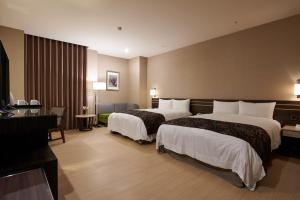 新竹市的住宿－迎曦大飯店，酒店客房配有两张床和一张书桌