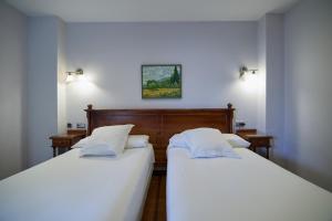 two beds sitting next to each other in a room at Hotel Villalegre in Avilés