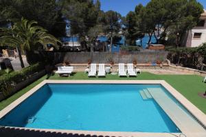 a swimming pool with two chairs and a table and chairs at Akrotiri in Santa Ponsa